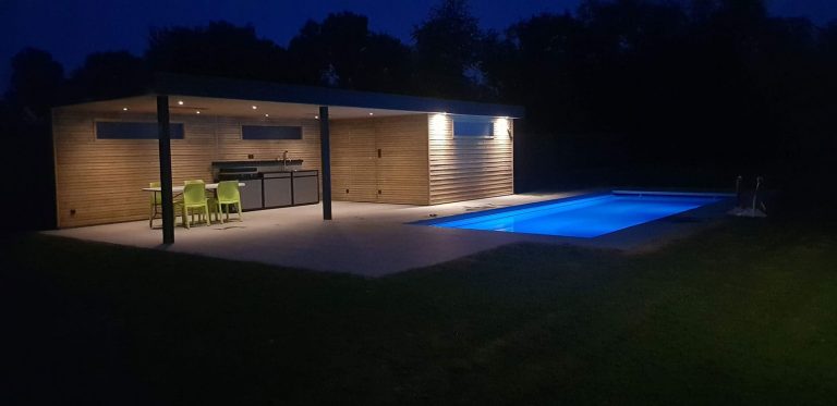 Pool-house en bois vu de nuit